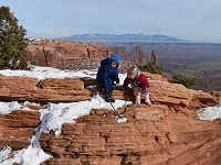 Kids on a rock, digging in snow