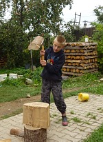 Kids learning to split wood.
