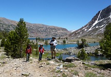 Three huffing figures on the back-drop of three mountain lakes.