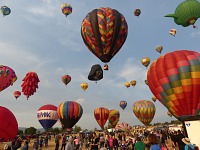 The sky was full of balloons and the meadow was full of people.