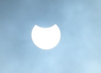 Eclipse behind clouds.