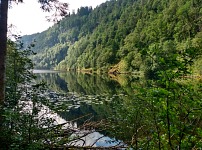 Kossdalsvatnet: okolní skalnaté svahy se odrážejí v hladině jezera. Kossdalsvatnet: okolní skalnaté svahy se odrážejí v hladině jezera.