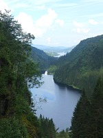 Kossdal: údolí se dvěma jezery (to druhé není přes les vidět) a vzadu je zátoka Mjøsvågen a fjord. Kossdal: údolí se dvěma jezery (to druhé není přes les vidět) a vzadu je zátoka Mjøsvågen a fjord.